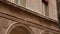 Building facade with stone columns, arches, decorative stucco elements, windows