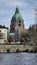 A building with a green dome stands next to the river under the sky Hanover Germany