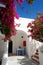 Building of hotel in traditional Greek style and Bougainvillea flowers, Santorini island