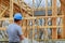 A building inspector surveys a new home build in construction site checking new building in progress