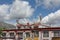 Building in Lhasa made of white brick with carved window fences and prayer flags in shape of yak horns on top, sights in