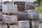 Building materials on pallets, red bricks paving stone. Warehouse building materials in the open. Bricks and building