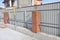 Building metal, bricks fence with iron bar framework. Install fencing.