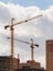 building process of large residential apartment building with crane on cloudy sky background