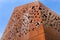 A building with raw metal walls covered with rust, cut out shapes of crosses.