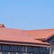 A building with a red-brown roof. Modern materials of finish and