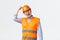 Building sector and industrial workers concept. Enthusiastic male engineer in reflective clothing knocking on helmet and