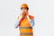 Building sector and industrial workers concept. Thoughtful asian engineer working construction area, wearing helmet and