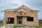 Building site with unfinished brick house with wooden roofing frame for future roof under construction