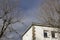 Building. White colored building next to some bare and leafless trees in the surroundings.