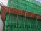 Building wrapped in traditional Chinese scaffolding made of bamboo for worker to repair or replace air conditioner above window