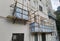 Building wrapped in traditional Chinese scaffolding made of bamboo for worker to repair or replace air conditioner above window