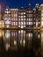 Buildings along the Damrak at Night in Amsterdam