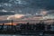 Buildings of Basel city near the Rhine river under cloudy sky at sunset