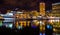 Buildings and boats reflecting in the Inner Harbor at night, Baltimore, Maryland.