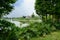 Buildings in lakeside plants and trees on cloudy summer day