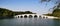 Buildings, mountains, trees and Bridges under the blue sky and white clouds