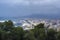 Buildings, port, bay, ships and mountains against a cloudy sky. Dramatic sky over the city. Beautiful view