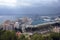 Buildings, port, bay, ships and mountains against a cloudy sky. Dramatic sky over the city. Beautiful view