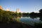 Buildings reflect in the lake at Central Park with blue sky