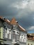 Buildings in sunlight with storm clouds incoming.