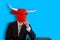 Buisinessman with a bull mask sitting with blue background