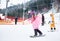 Bukovel, Ukraine - December 09, 2018: woman freeriding on snowboard in pink costume with colorful wig with diluted hands