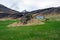 Bulandstindur mountain peak with snow on it. Blue abandoned farmhouse infront of it.