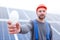 A bulb in the hand of an employee in focus on a blurred background of solar panels