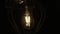 Bulb moves on a wire naturally. Lamp swinging on a black background. Slow motion.