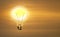 Bulb with shining gold brain on sun rising sky.