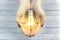 Bulb in woman hand,Realistic photo image. Turn on tungsten light