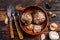 Bulbs and cloves of fermented black garlic in a plate. Dark wooden background. Top view