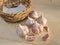 Bulbs and cloves of garlic grown in organic gardening, on a wooden board, next to the small wicker basket