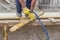 Bulder worker sawing wood board with hand saw