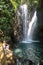 Buleleng - A man sitting on the rocks under the Gitgit Twin Waterfall