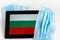 Bulgaria flag covered by surgical protective mask for coronavirus COVID-19 prevention