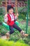 Bulgarian boy in ethnic folklore costume with traditional embroidery on a swing in a garden at his family house