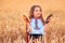 Bulgarian girl, beautiful woman, eating freshly baked banitsa, cheese pie during harvest In golden wheat field