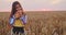 Bulgarian girl, beautiful woman, eating freshly baked bread during harvest In golden wheat field