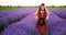 Bulgarian girl in folklore costume running through flowers in lavender field