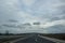 Bulgarian highway with cars and truck, asphalt road with road signs on the side, foggy weather