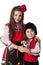 Bulgarian kids boy and girl in traditional folklore costumes with spring flowers snowdrop and handcraft wool bracelet martenitsa