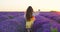 Bulgarian young girl or woman in folklore costume in enjoying sunset in lavender field