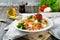 Bulgur with roasted peppers, tomatoes, parsley and feta cheese on a wooden background. Vegetarian dish. Selective focus