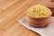 Bulgur in wooden bowl on brown bamboo board, close up. Rustic style, healthy dietary groats background.