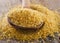 Bulgur in a wooden spoon on wooden background.