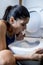 Bulimic woman feeling sick guilty fingers in mouth vomiting and throwing up in WC toilet
