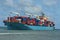 Bulk cargo ship  loaded with container sail trough the horizon in the ocean.