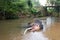 Bull Asian Elephant with tusks lying in the water in Pinnawala Sri Lanka